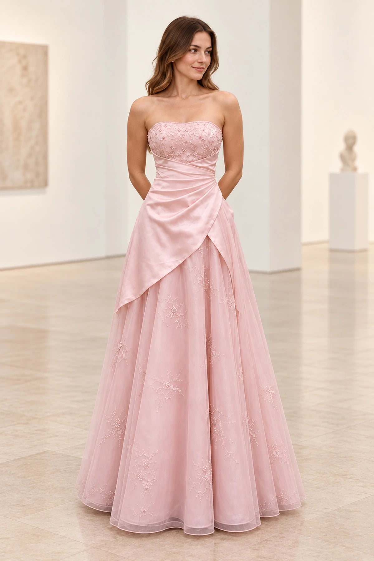Blush pink satin and tulle A-line prom dress with strapless neckline, floral beaded bodice, asymmetrical draped waist and floor length skirt by Graceprom