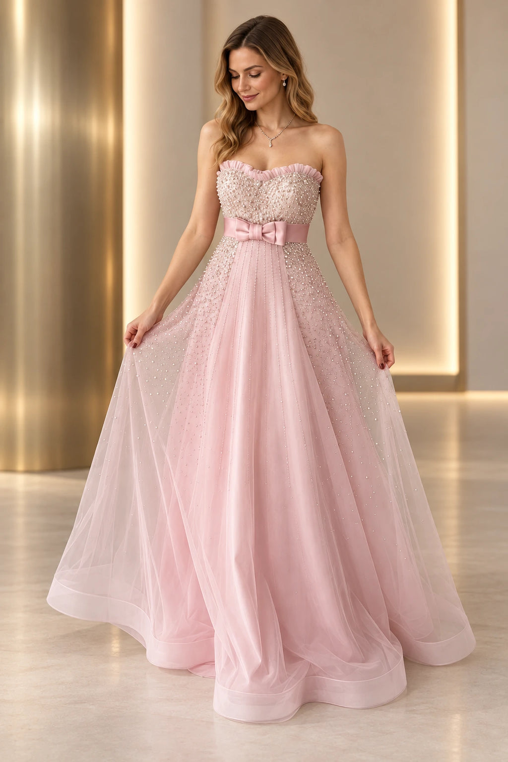 Blush pink beaded tulle A-line prom dress with strapless sweetheart neckline, sparkling embellished bodice, satin bow waist and flowing floor length skirt by Graceprom