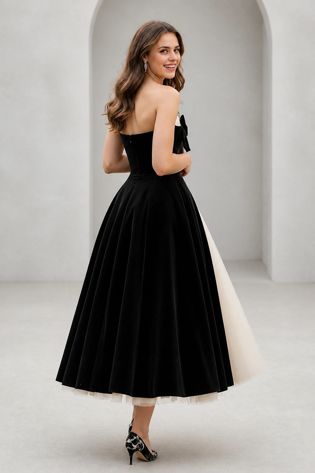 Back view of black and ivory tea length wedding guest dress with strapless bodice and zipper closure