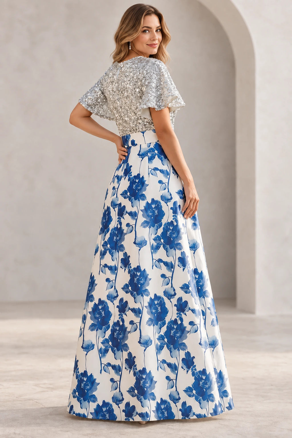 Back view of blue floral Mother of the Bride Dress with silver textured bodice and full floor-length skirt