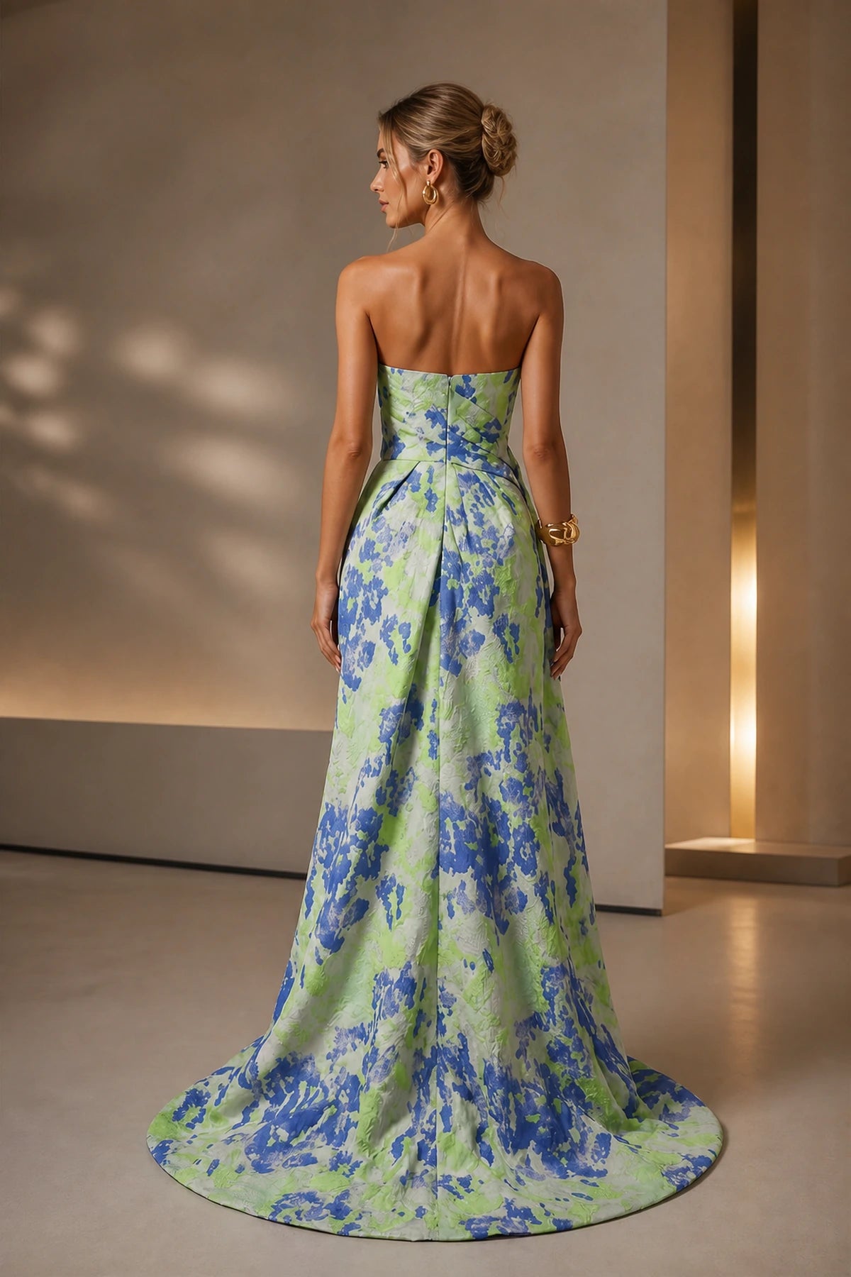 Back view of blue green floral wedding guest dress with strapless zipper back, full A-line skirt and sweeping train