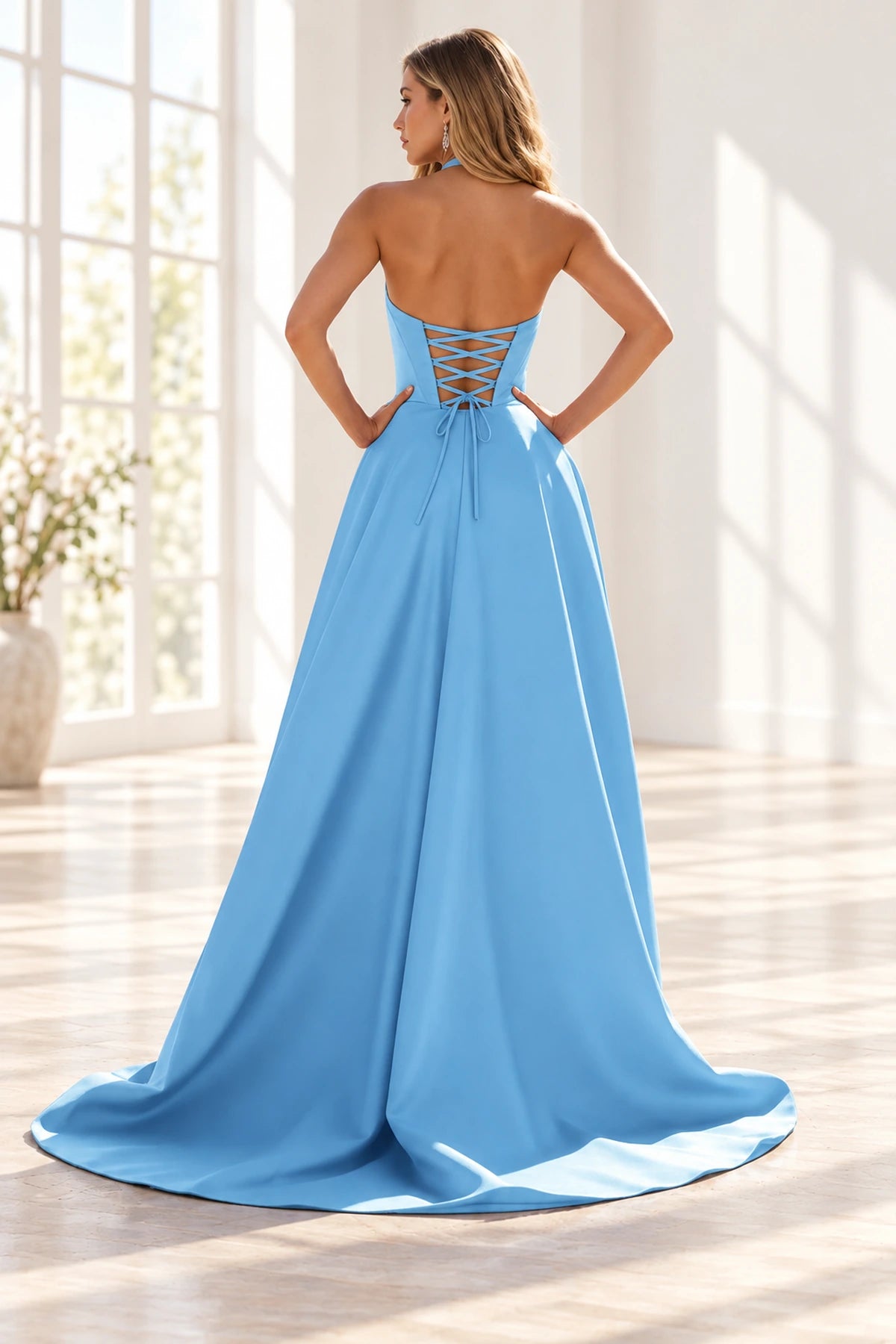 Back view of a baby blue halter prom dress with an open crisscross lace up back, waist bow and sweeping A-line train.