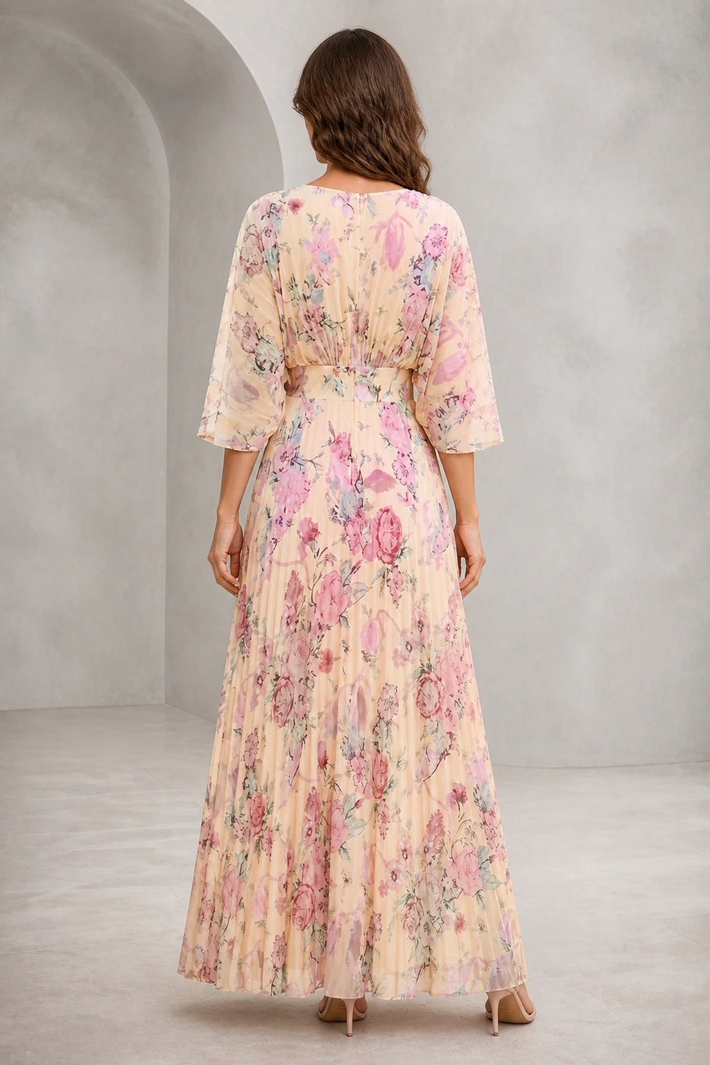 Back view of blush floral mother of the bride dress with flutter sleeves, closed back and flowing floor-length A-line skirt