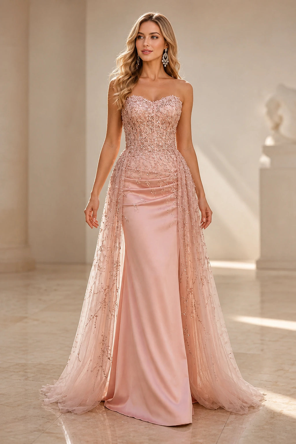 Blush pink strapless wedding guest dress with sweetheart neckline, beaded bodice, fitted sheath skirt and embellished tulle overlay