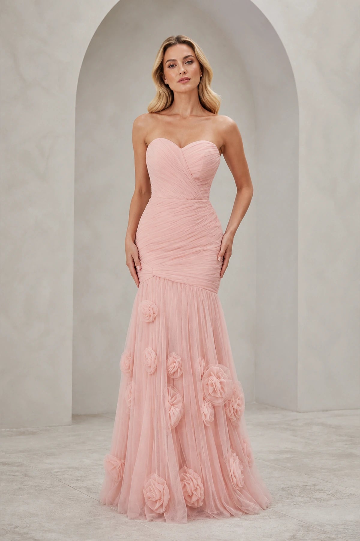 Blush pink strapless sweetheart mermaid wedding guest dress with ruched bodice and floral applique floor-length skirt