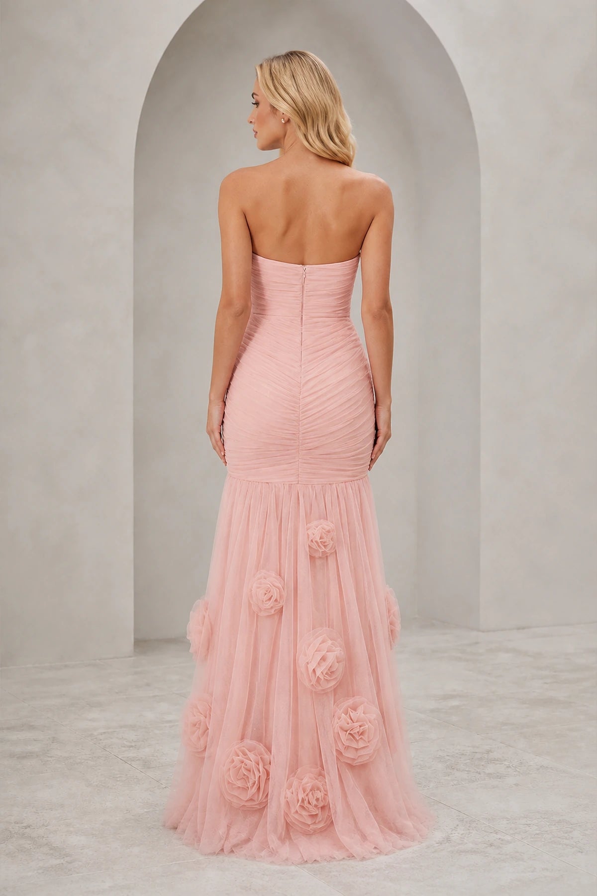 Blush pink strapless sweetheart mermaid wedding guest dress with ruched bodice and floral applique floor-length skirt