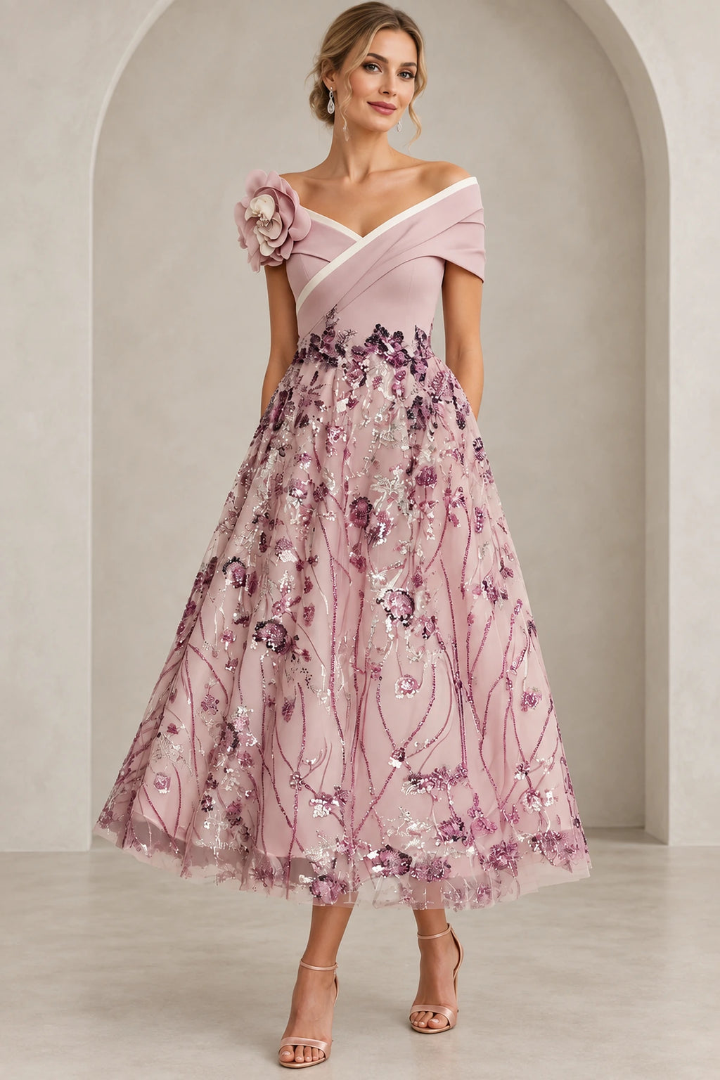 Blush pink A-line Mother of the Bride Dress with off-the-shoulder neckline, floral shoulder accent and embroidered tea-length skirt