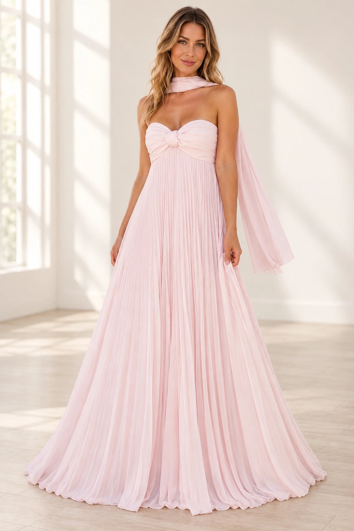 Blush pink A-line prom dress featuring a strapless sweetheart neckline, twisted ruched bodice, flowing pleated chiffon-look skirt, and matching neck scarf by Graceprom.