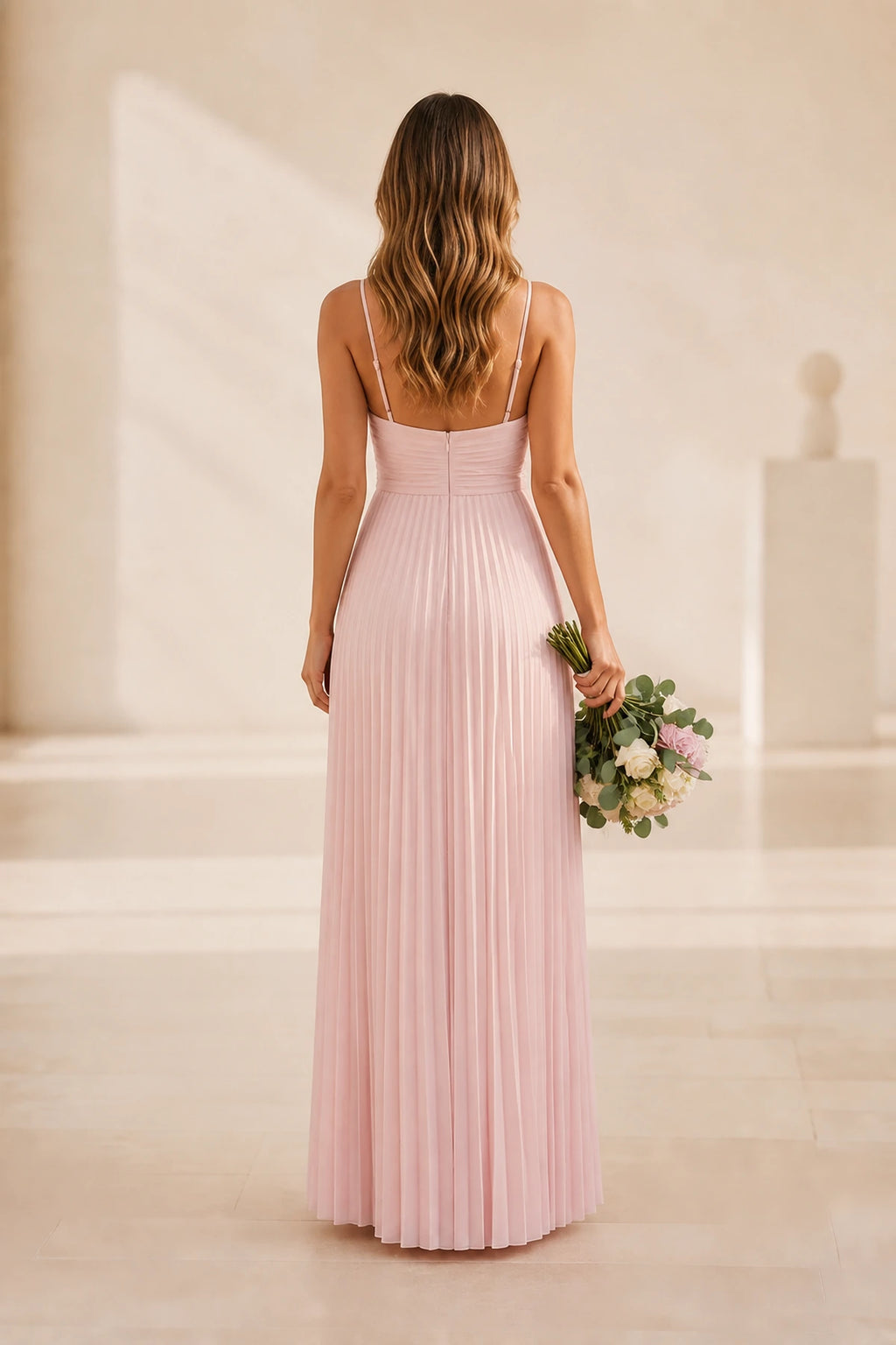 Back view of blush pink bridesmaid dress with spaghetti straps, center zipper and pleated floor-length skirt