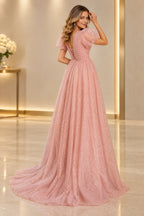 Blush pink prom dress featuring a deep V back, lower-back crisscross lacing, sheer puff sleeves, and a sparkling skirt with train.