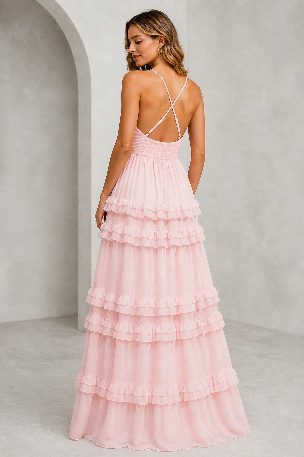 Back view of blush pink bridesmaid dress with crisscross spaghetti straps, open back and tiered ruffle A-line skirt