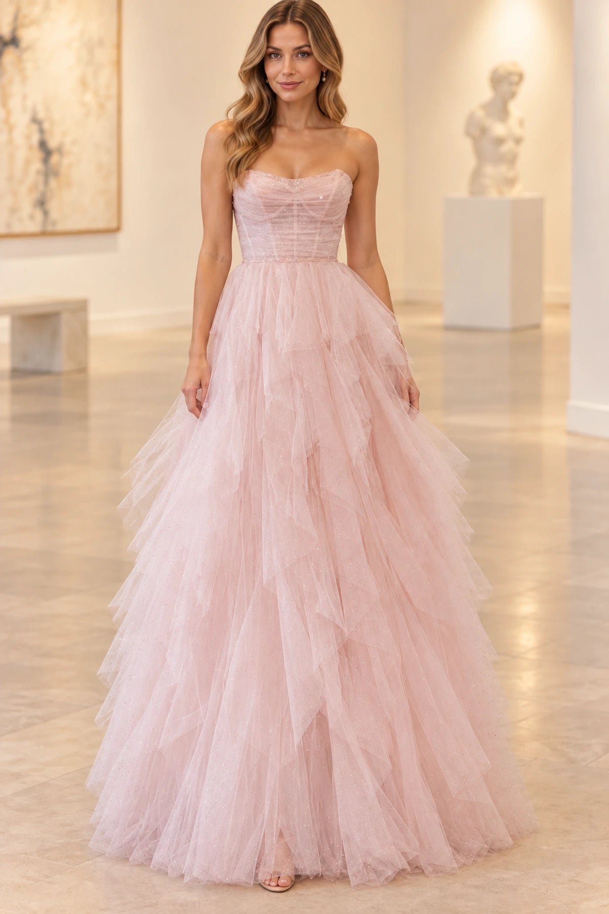 Blush pink princess prom dress featuring a strapless sweetheart neckline, ruched corset bodice, and cascading layered glitter tulle ruffles by Graceprom.