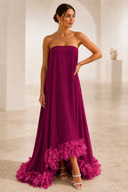 Burgundy strapless A-line wedding guest dress with straight neckline, flowing skirt and fuchsia feather-style hem