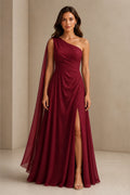 Burgundy one shoulder prom dress with flowing chiffon cape, ruched waist, high side slit and floor length A-line silhouette, front and back view