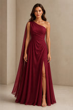 Burgundy one shoulder prom dress with flowing chiffon cape, ruched waist, high side slit and floor length A-line silhouette, front and back view
