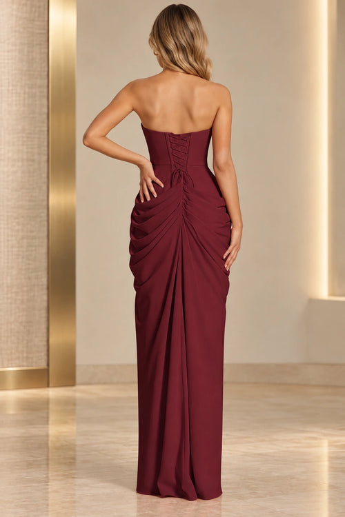 Burgundy prom dress with a low lace-up back, matching panel, center-back ruching, and cascading draped folds.