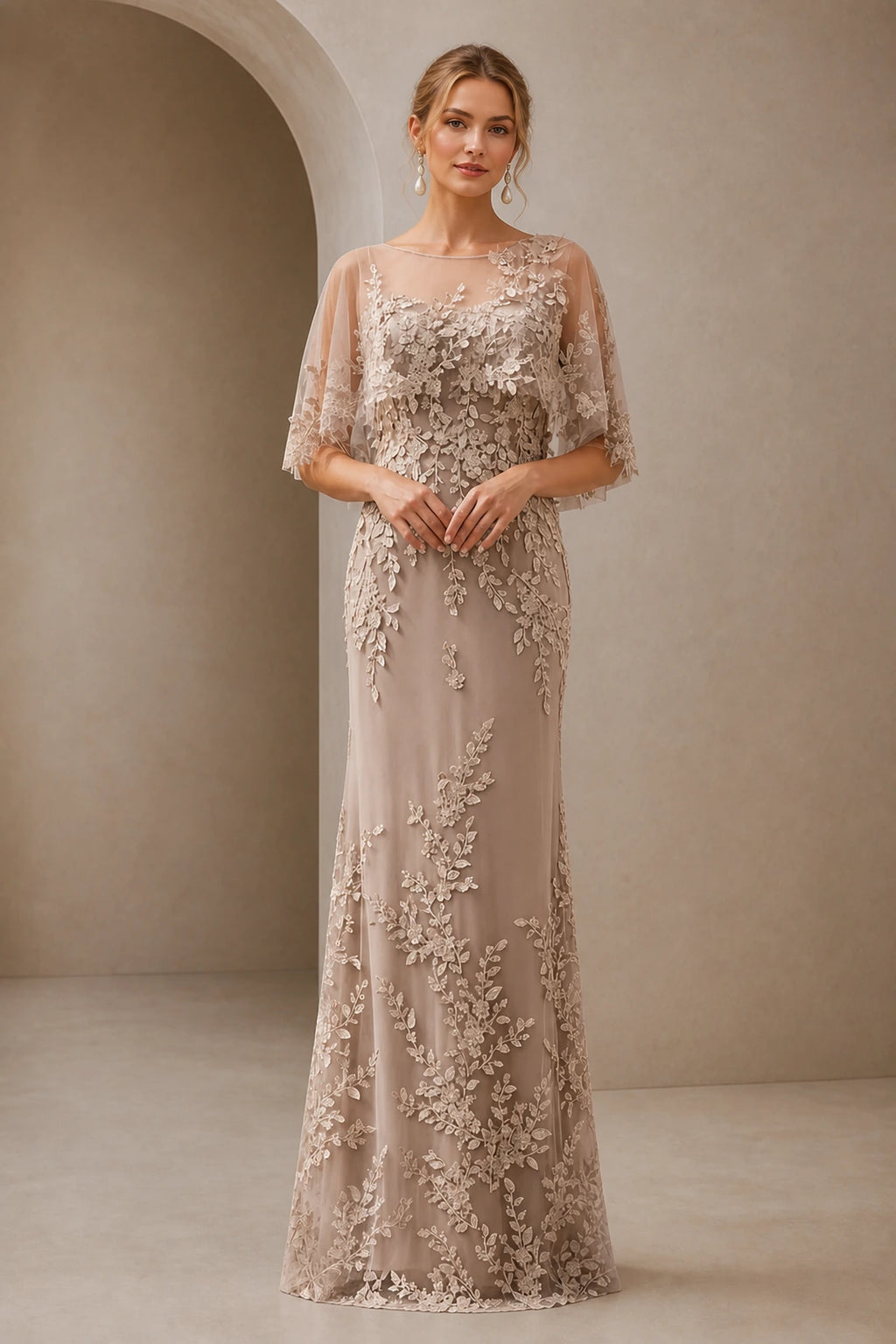 Champagne mother of the bride dress with illusion neckline, lace appliqués, cape sleeves and floor-length sheath silhouette