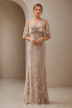 Champagne mother of the bride dress with illusion neckline, lace appliqués, cape sleeves and floor-length sheath silhouette