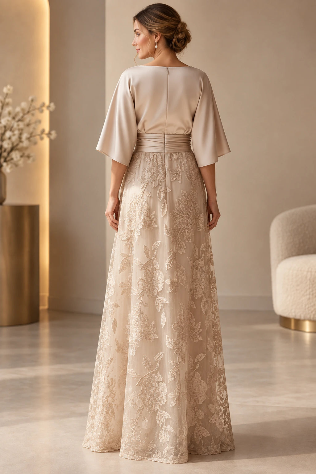 Back view of champagne Mother of the Bride Dress with cape sleeves, ruched waistband and floral lace skirt