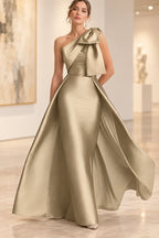 Champagne one-shoulder Mother of the Bride Dress with oversized bow and flowing floor-length overlay skirt