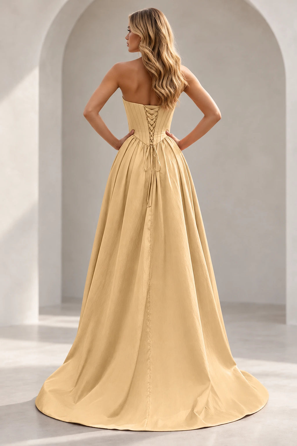 Champagne prom dress showing a paneled lace-up back with matching backing panel, long waist ties, full gathered skirt, and train.