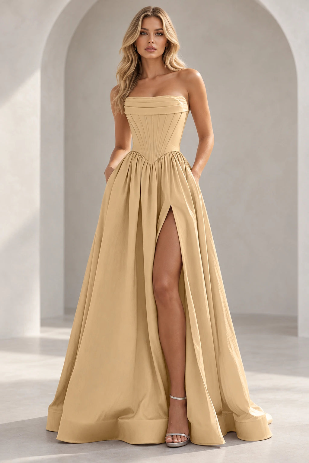 Champagne strapless A line prom dress with a pleated foldover neckline, pointed corset-style waist, gathered skirt, and thigh-high slit.