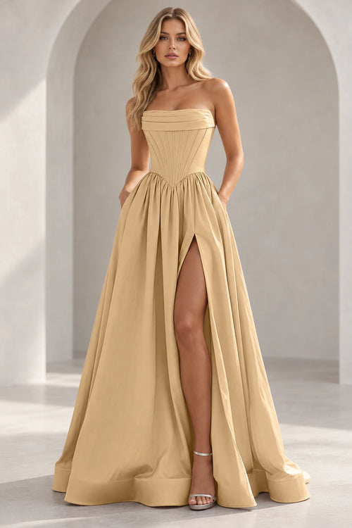 Champagne strapless A line prom dress with a pleated foldover neckline, pointed corset-style waist, gathered skirt, and thigh-high slit.