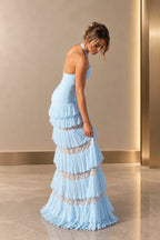 Side-back view of a light blue Graceprom prom dress with an open halter back, fitted ruched bodice and tiered chiffon skirt with sheer lace inserts.