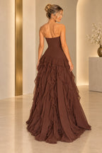 Back view of chocolate brown chiffon prom dress featuring strapless fitted bodice, center zipper, drop waist and cascading layered ruffle skirt