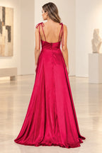 Deep red prom dress showing shoulder tie bows, thin back straps, a low curved neckline, center zipper, and flowing floor-length skirt.