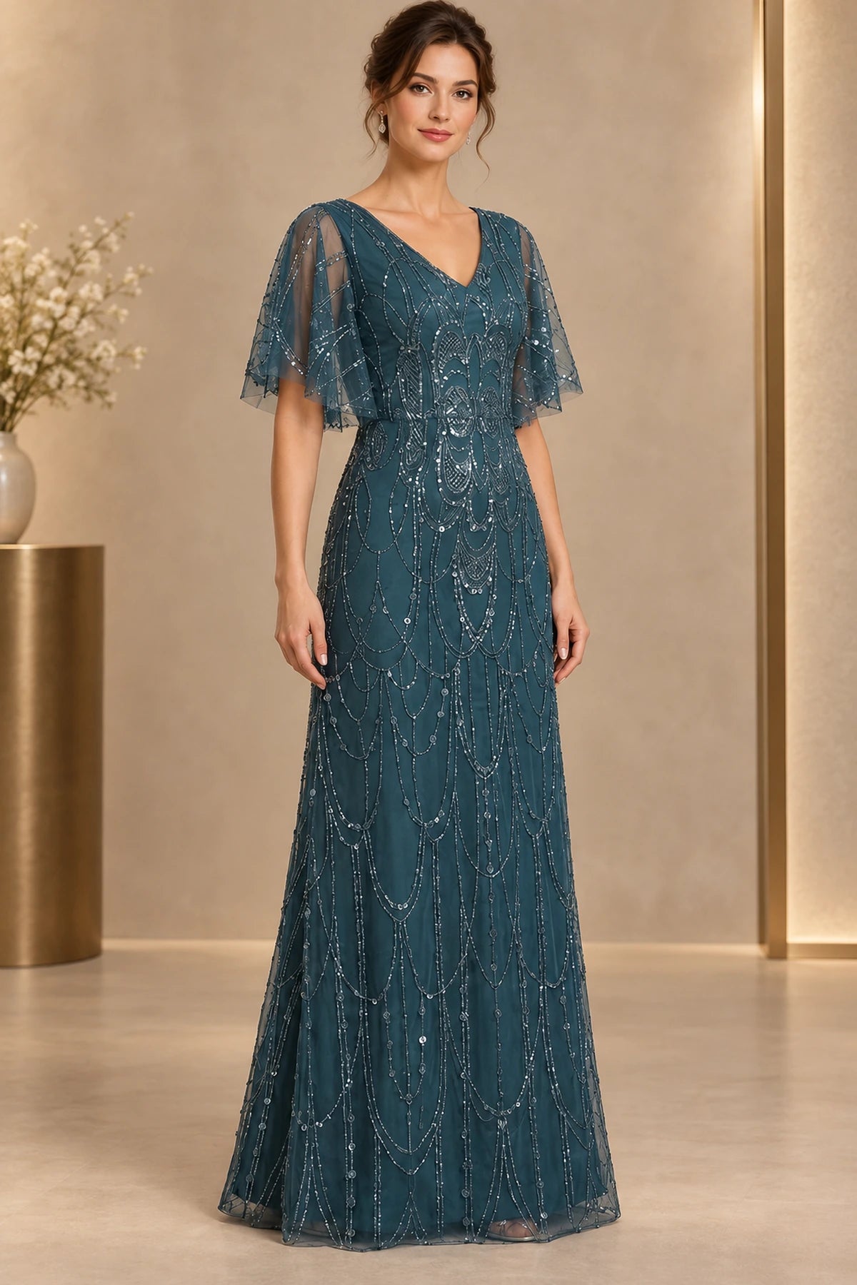 Deep teal mother of the bride dress with V neckline flutter sleeves and all over beaded detailing