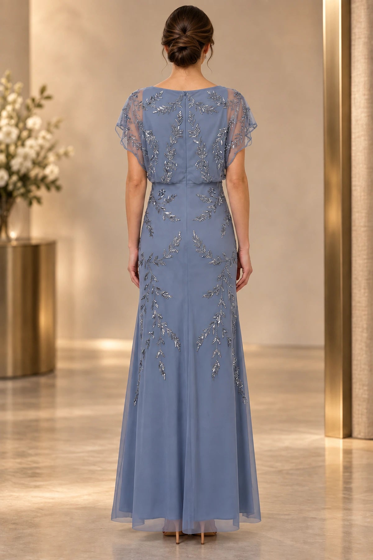 Back view of dusty blue mother of the bride dress with cape sleeves and leaf beaded embellishment