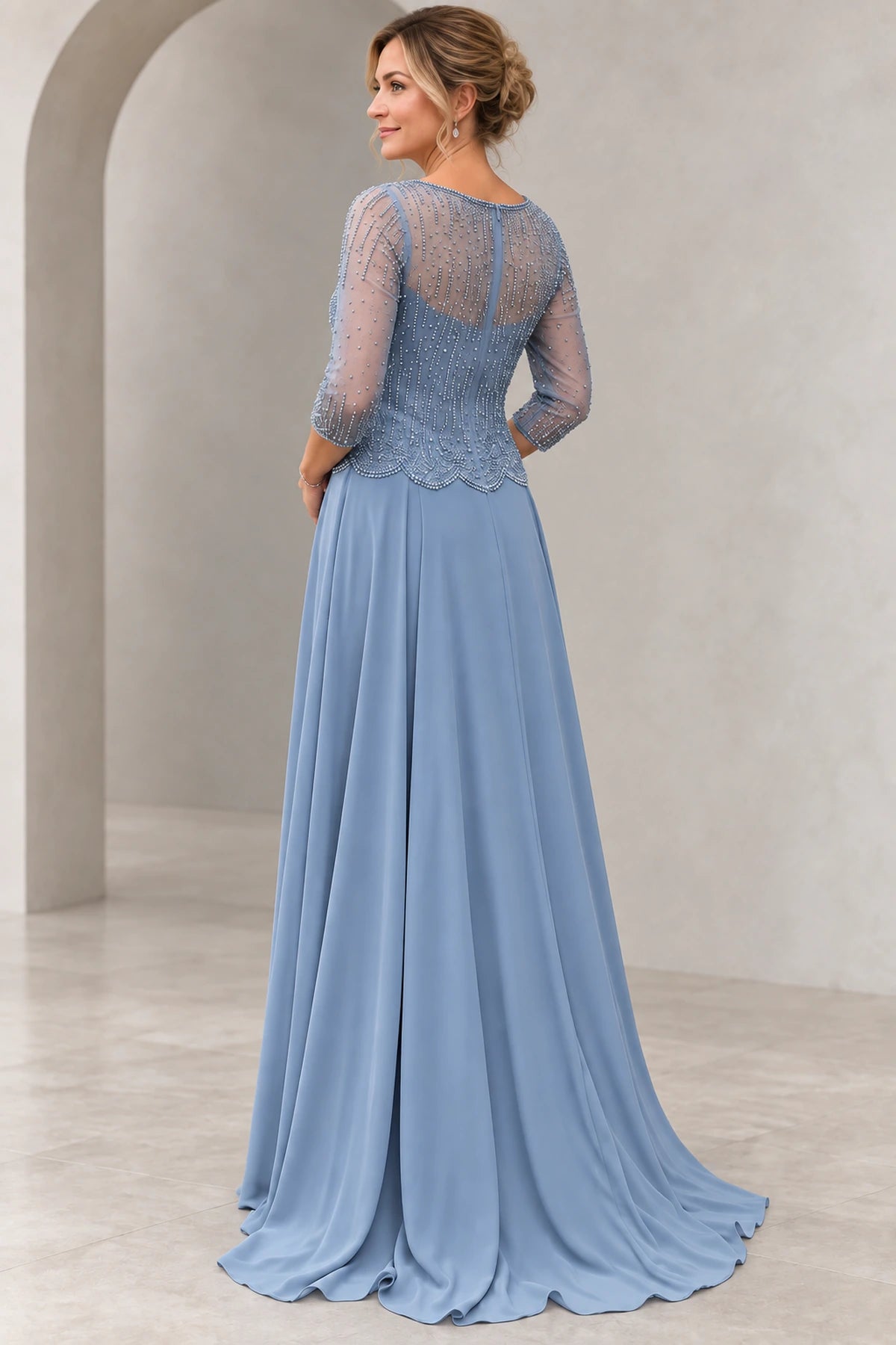 Back view of dusty blue Mother of the Bride Dress with sheer beaded illusion back, center zipper and flowing floor-length skirt