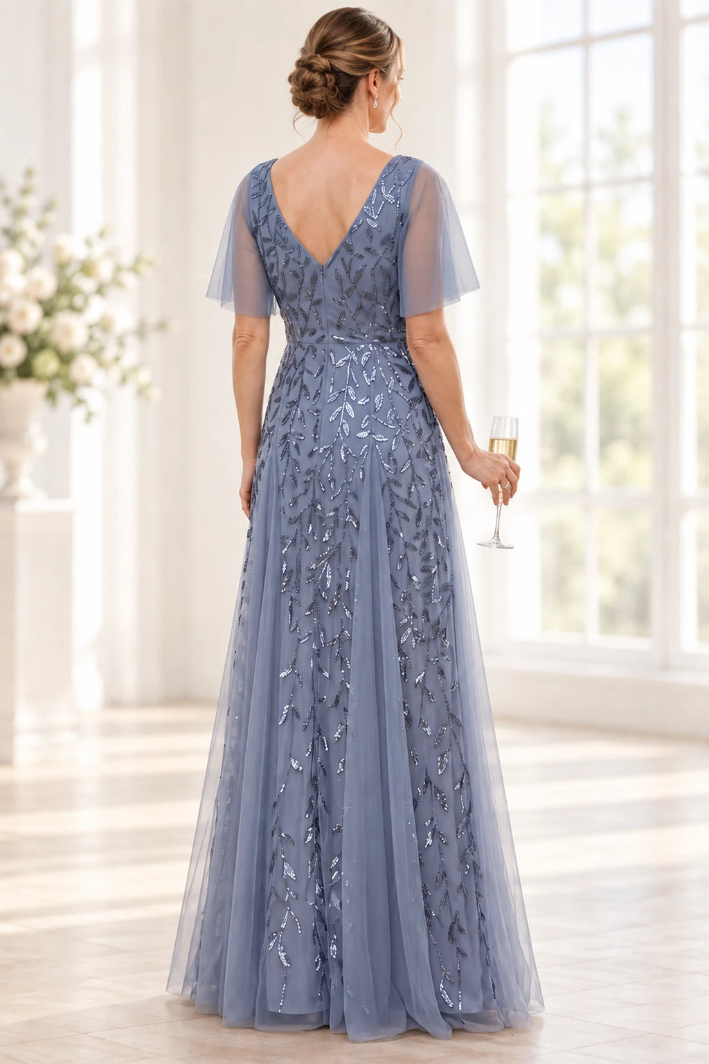 Back view of dusty blue Mother of the Bride Dress with V-back flutter sleeves and embellished floor-length skirt