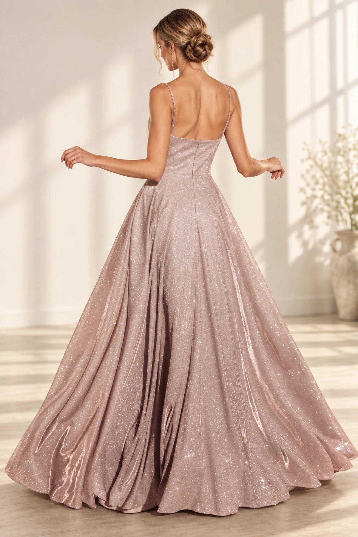 Back view of dusty rose glitter A-line prom dress featuring thin spaghetti straps, low scoop back, center zipper closure, and flowing floor-length skirt.