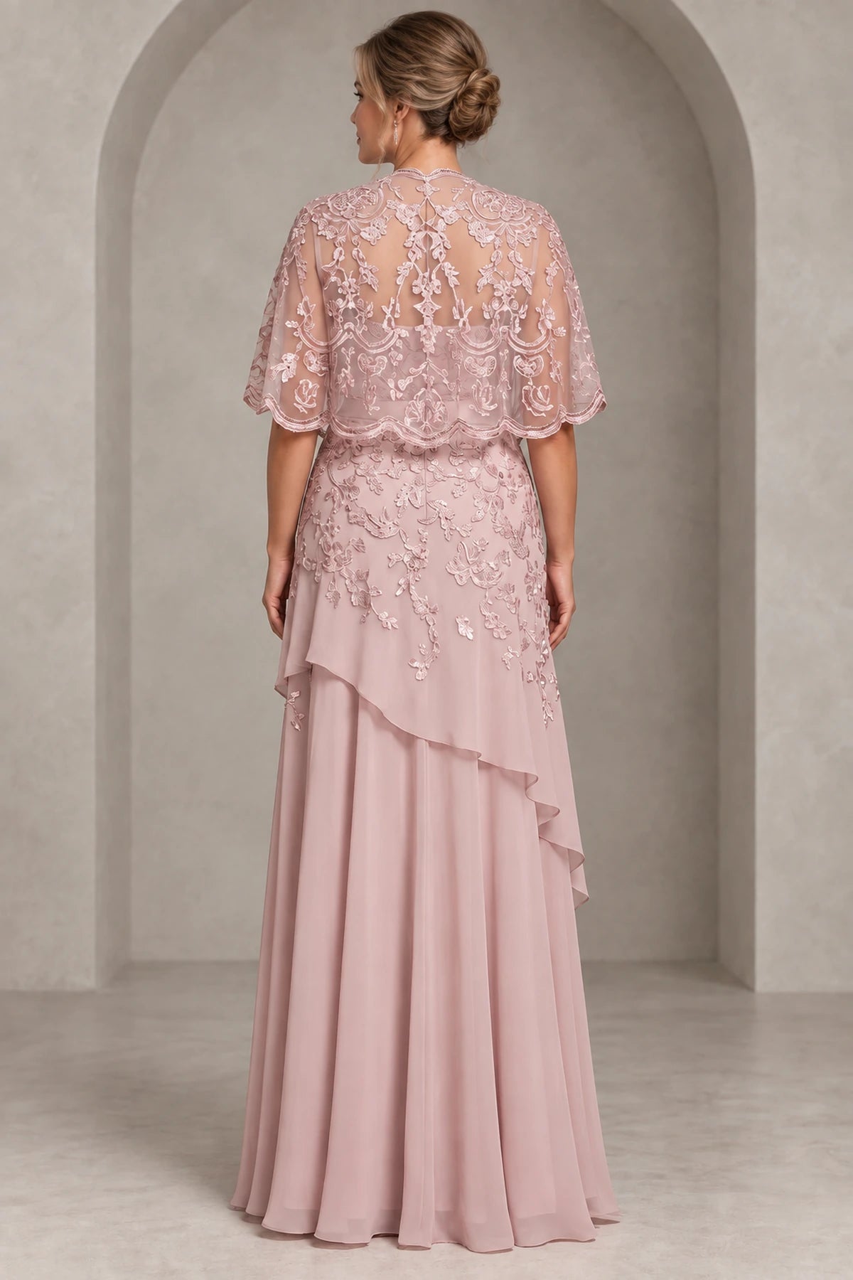 Back view of dusty rose Mother of the Bride Dress with floral illusion lace cape, sheer back and layered chiffon floor-length skirt