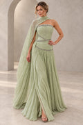 Elegant sage green chiffon prom dress featuring a strapless beaded bodice, asymmetrical cape draping, sparkling waist details and flowing A-line skirt