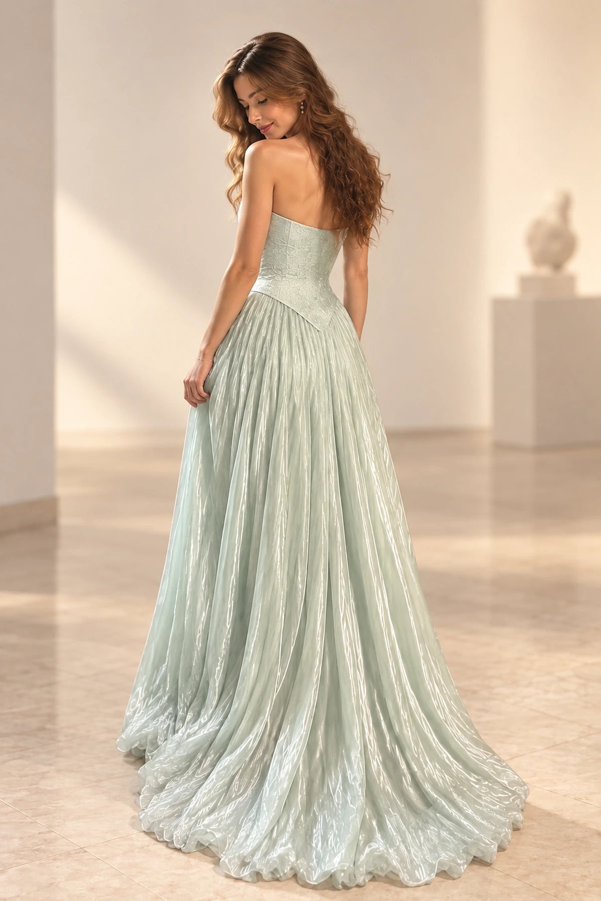 Ice blue chiffon prom dress back view featuring a strapless low back, fitted bodice, pointed waist and soft flowing A-line skirt