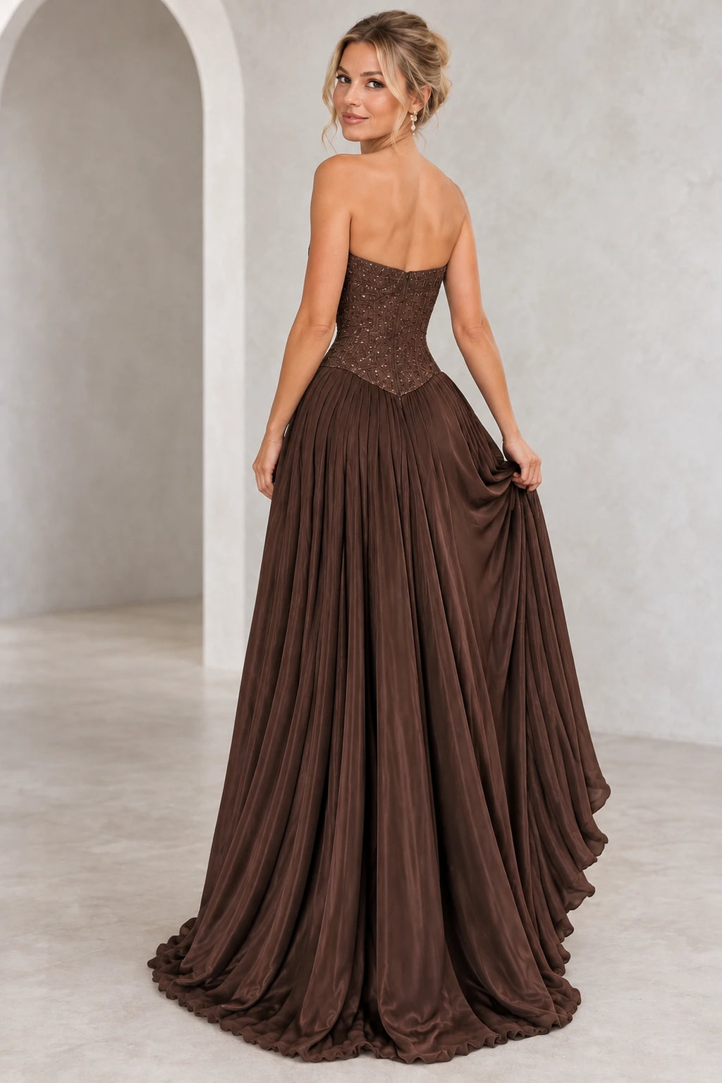 Chocolate brown chiffon A-line prom dress back view featuring a strapless embroidered corset, delicate beading, center zipper and flowing floor-length pleated skirt