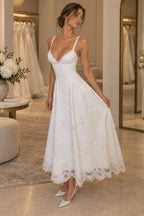 White embroidered lace A-line wedding guest dress with plunging V neckline, lace straps, floral embroidery and scalloped tea length skirt by Graceprom