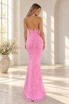 Back view of pink floral lace evening dress featuring halter neckline, open back, ruched waist and fitted mermaid floor length skirt
