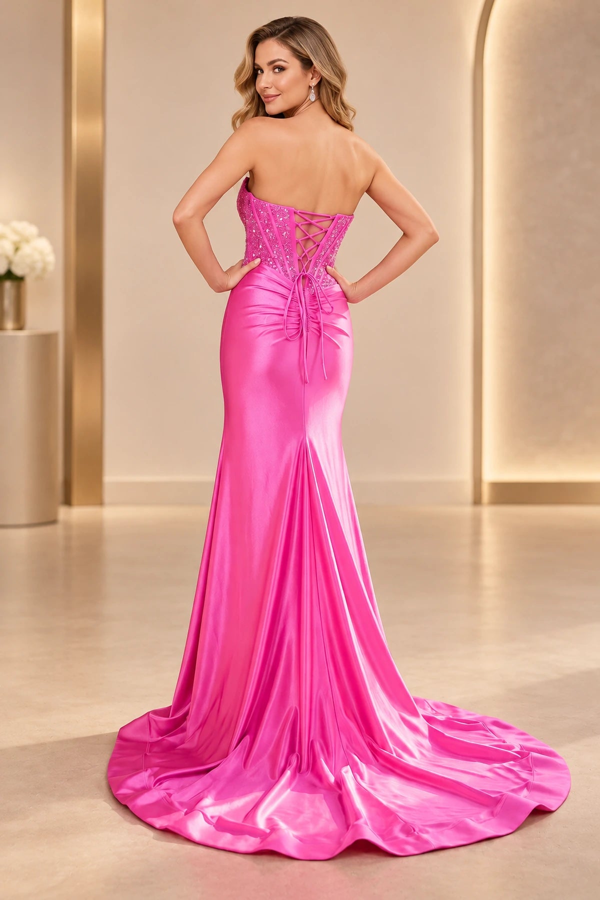 Back view of fuchsia mermaid prom dress featuring an embellished lace-up corset, crisscross tie ribbons, fitted satin-look skirt, and dramatic sweep train.