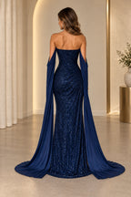 Navy blue sequin mermaid prom dress back view showing a fitted sparkling bodice, center zipper, long chiffon cape sleeves and floor-length skirt