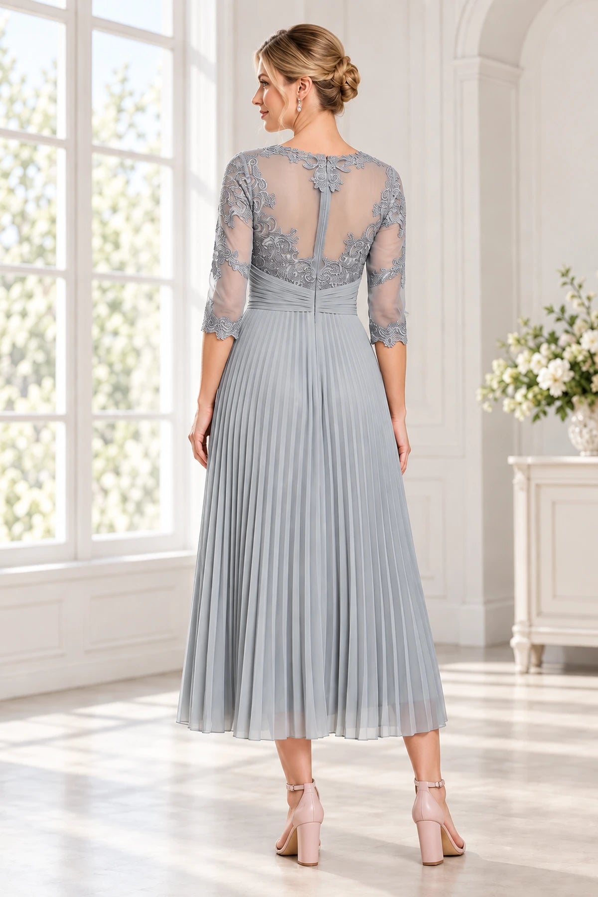 Back view of a gray tea-length wedding guest dress with sheer illusion back lace applique 3/4 sleeves and pleated skirt