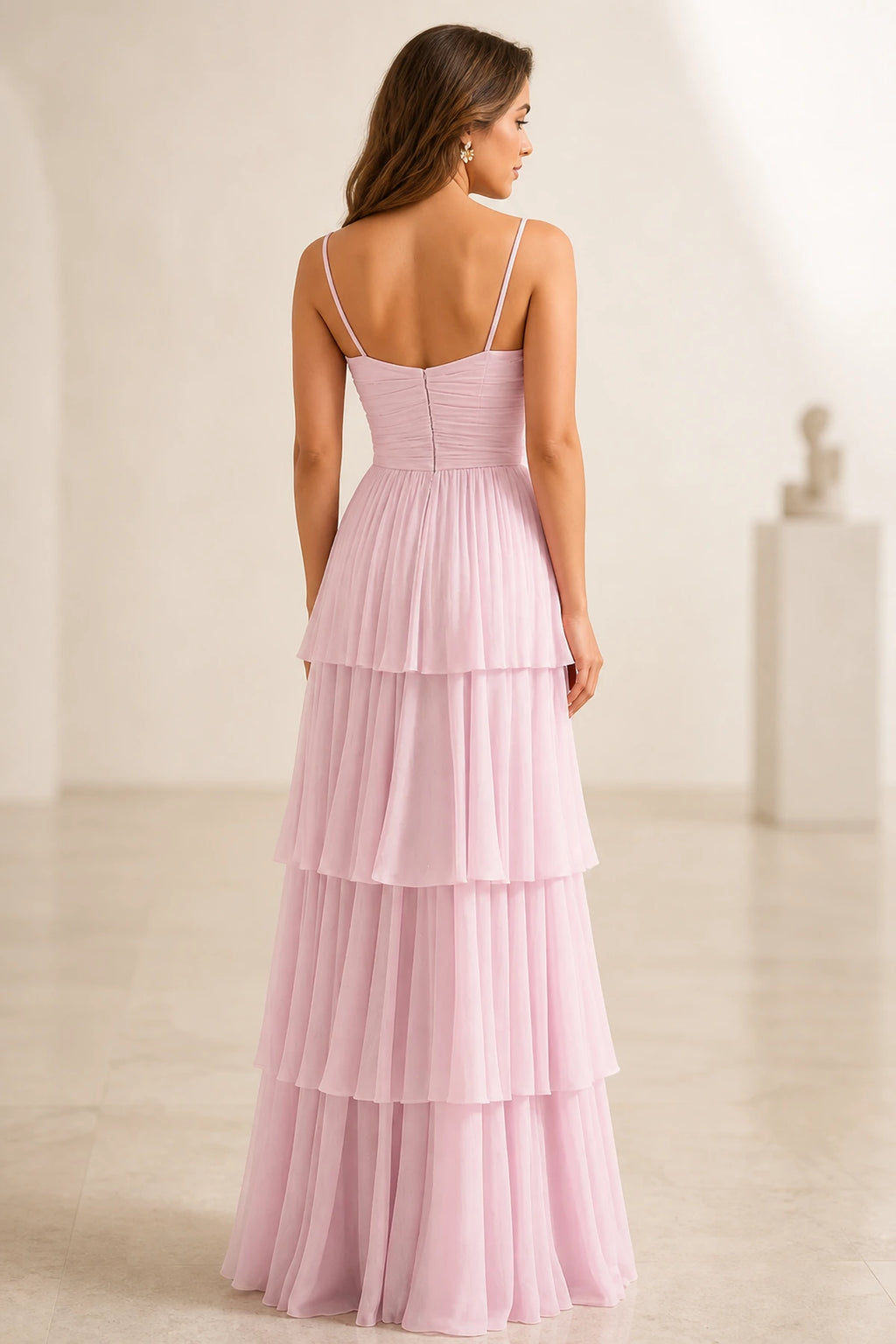 Back view of light pink tiered wedding guest dress with spaghetti straps and zipper back
