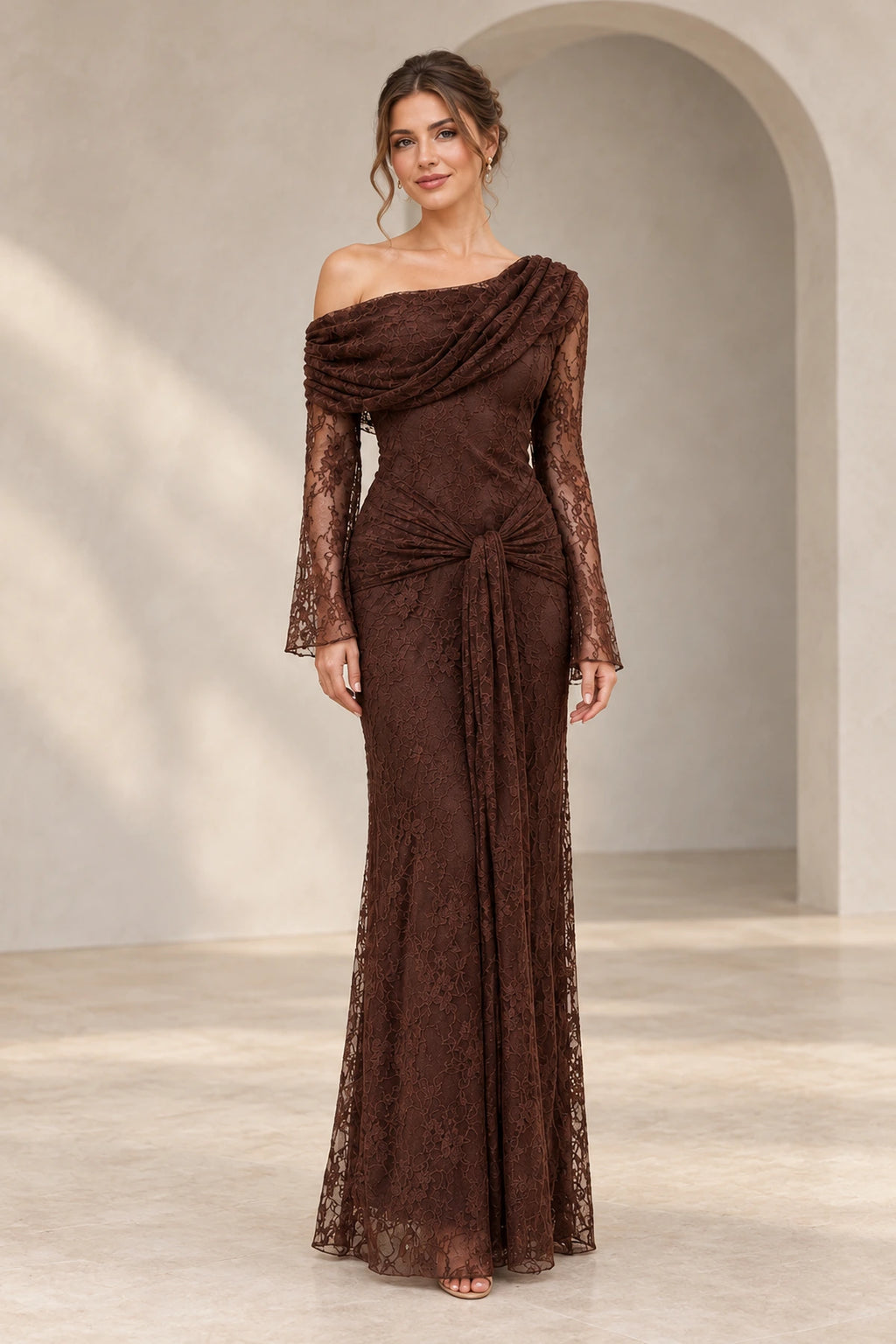 Chocolate brown floral lace wedding guest dress featuring an asymmetric off-the-shoulder neckline, sheer long sleeves, gathered waist, and floor-length sheath silhouette.