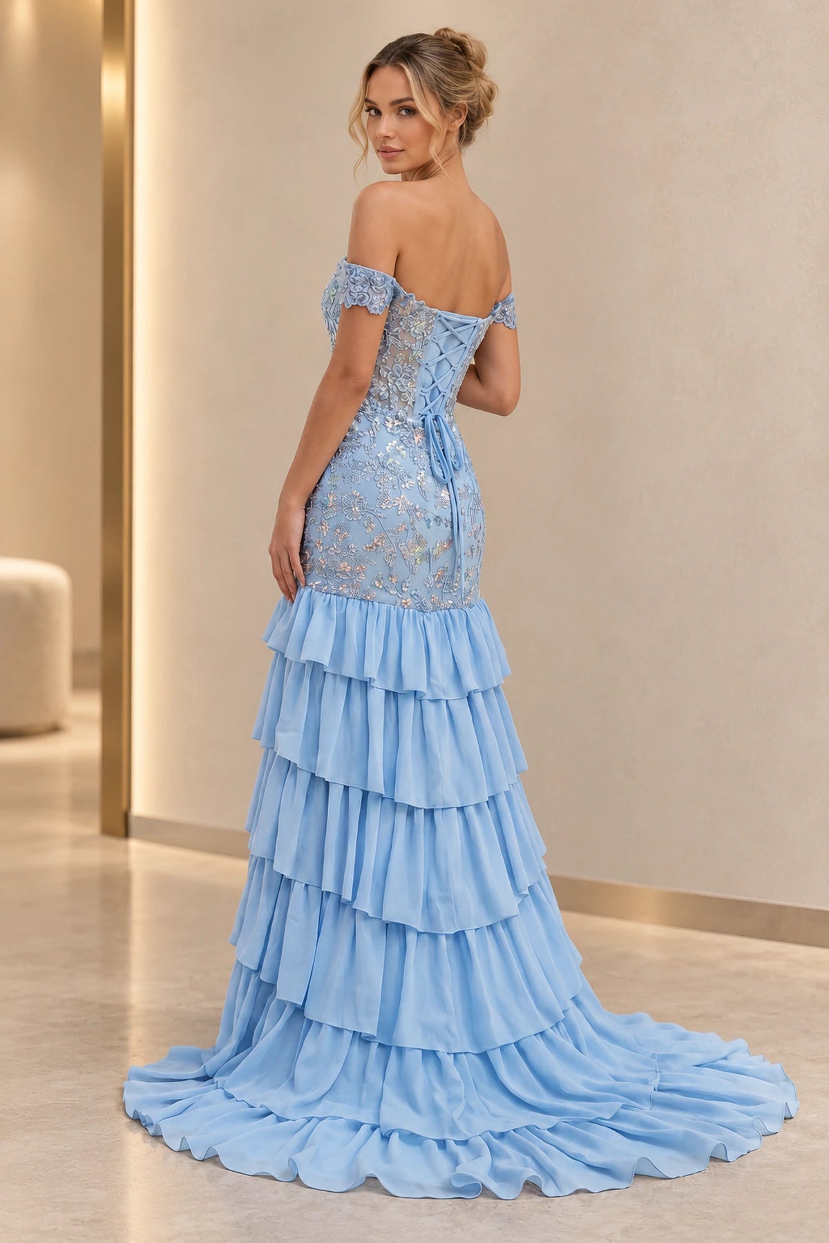 Back view of light blue mermaid prom dress featuring floral embroidery, off-the-shoulder sleeves, lace-up corset and cascading ruffle sweep train.