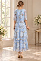 Back view of light blue Mother of the Bride Dress with floral embroidery, sheer sleeves and layered tiered skirt