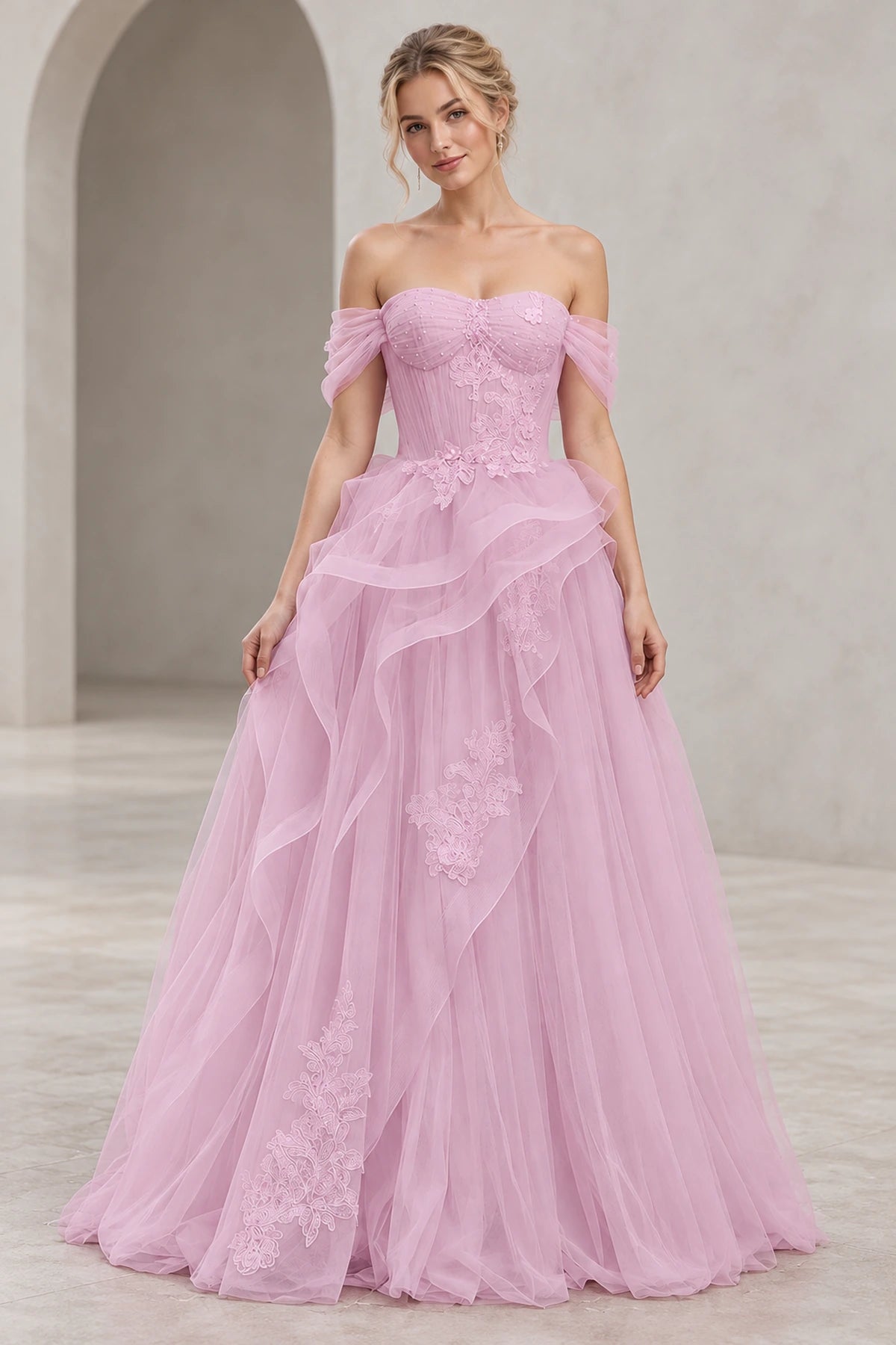 Light pink A-line tulle prom dress featuring a sweetheart neckline, off-the-shoulder sleeves, floral lace corset bodice, cascading ruffles, and floor-length skirt by Graceprom.