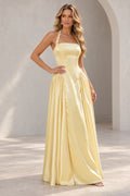 Light yellow A line prom dress with pearl-like halter strap details, a straight neckline, elongated bodice, and gathered side skirt panels.